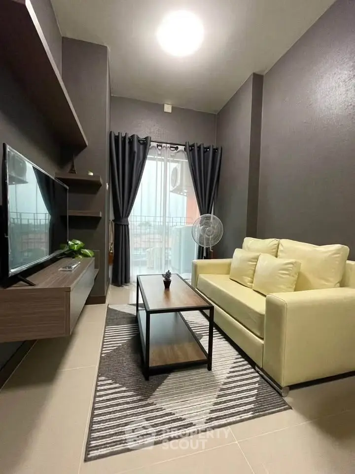 Modern living room with sleek furniture and balcony view, perfect for urban living.