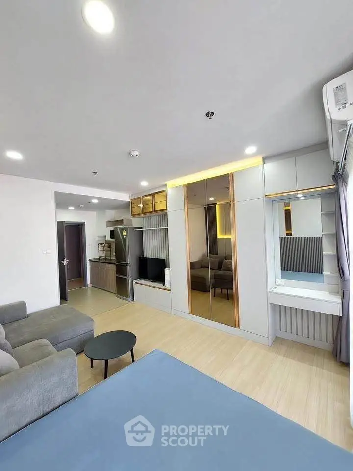 Modern living room with sleek design, featuring a cozy gray sofa, stylish built-in storage, and elegant lighting.