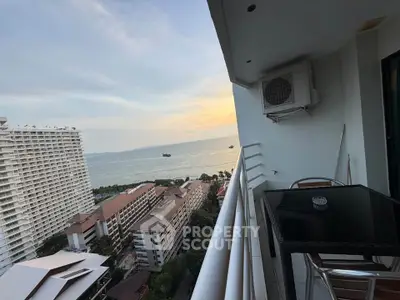 Stunning ocean view from high-rise balcony with modern outdoor seating.