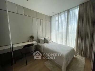 Modern bedroom with large windows and elegant decor, featuring a cozy bed and stylish desk.