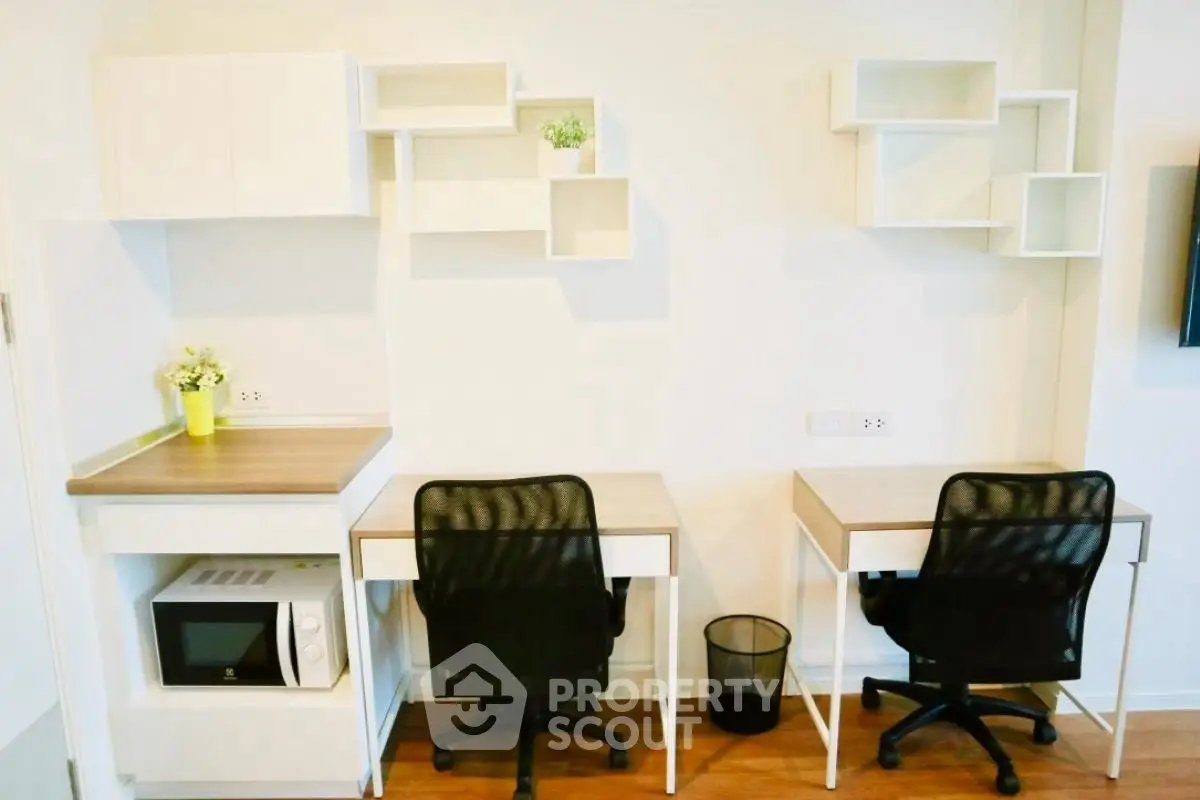Modern study area with dual desks and shelving in a bright apartment.