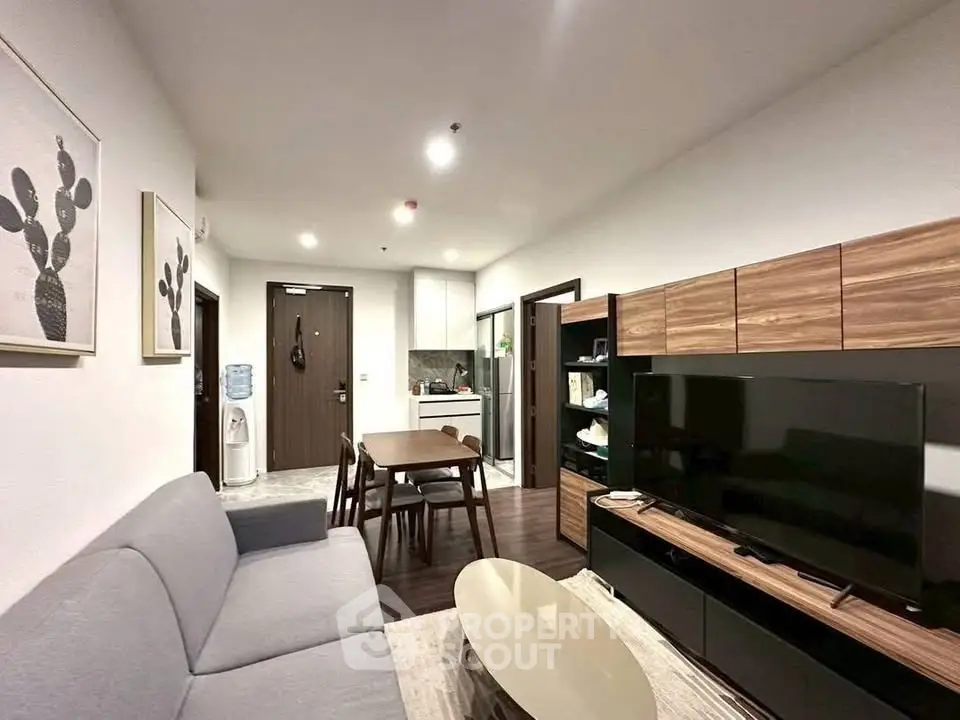 Modern living room with sleek furniture and open kitchen layout in a stylish apartment.