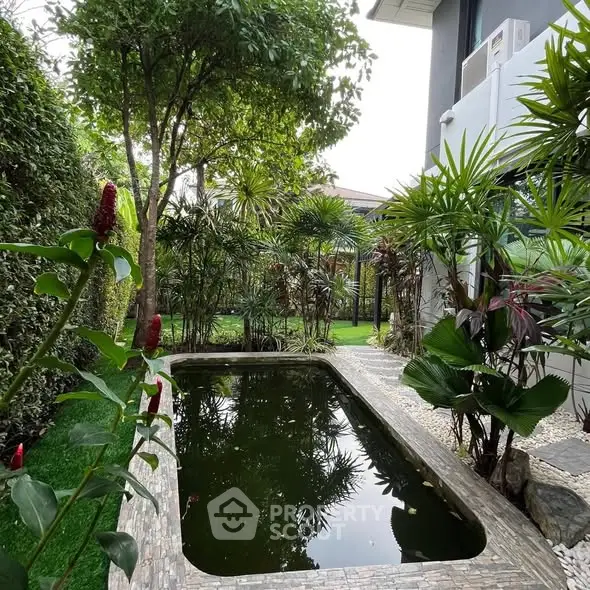 Lush garden with serene pond and modern building exterior