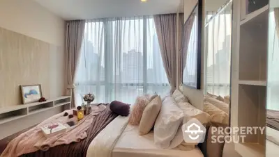 Luxurious bedroom with city view, elegant decor, and cozy ambiance.