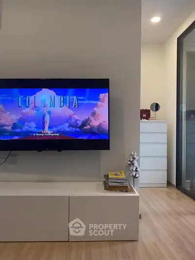 Modern living room with wall-mounted TV and sleek storage unit, showcasing a cozy and stylish interior design.