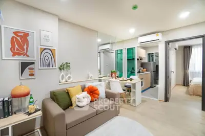 Modern open-plan living room with stylish decor and compact kitchen in a cozy apartment.