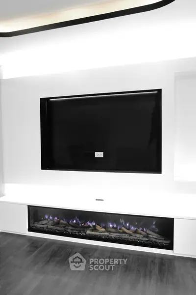 Modern living room with sleek built-in fireplace and TV setup.