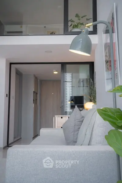 Modern living room with stylish grey sofa and elegant floor lamp