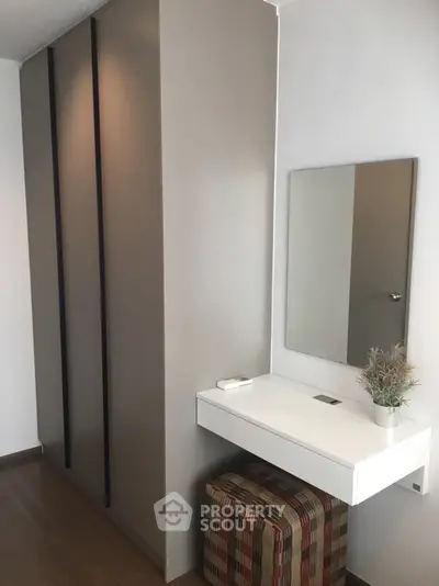 Modern minimalist bedroom with sleek wardrobe and stylish vanity area.