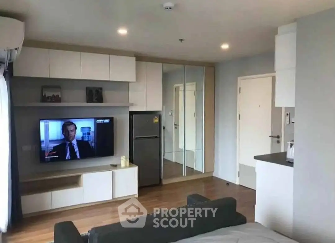Modern living room with sleek furniture and mirrored wall in a stylish apartment.