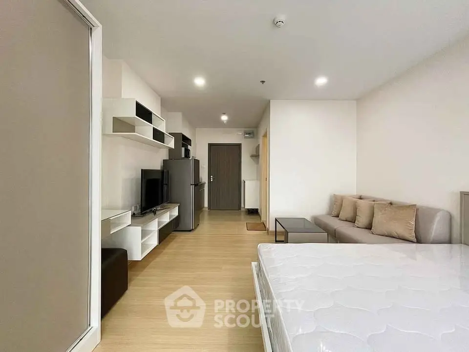 Modern studio apartment with sleek design, featuring a cozy living area, compact kitchen, and comfortable sleeping space.