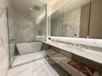 Luxurious modern bathroom with marble finishes and glass shower enclosure