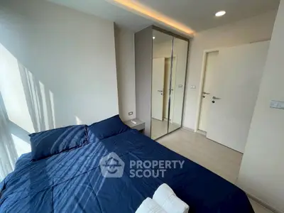 Modern bedroom with mirrored closet and natural light
