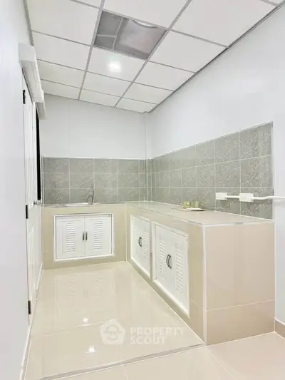 Modern kitchen with sleek cabinets and tiled backsplash in a bright, minimalist design.