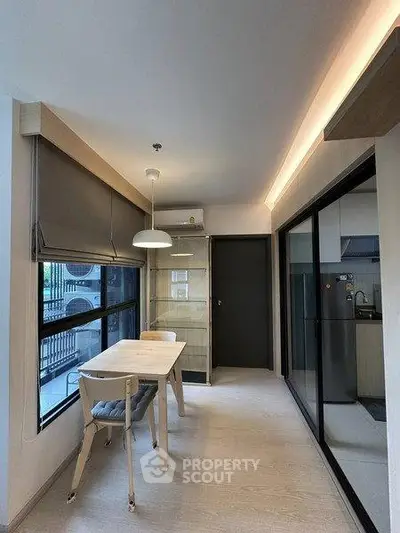 Modern dining area with natural light and sleek design, adjacent to a stylish kitchen.