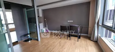 Spacious modern living room with wooden flooring and large windows in a stylish apartment.