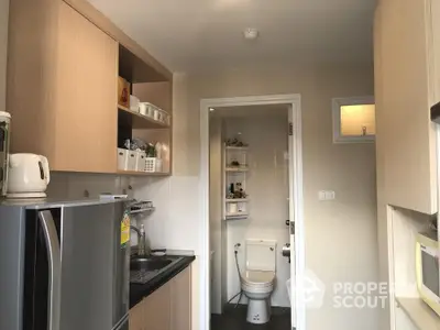 Compact kitchen with modern appliances and adjacent bathroom