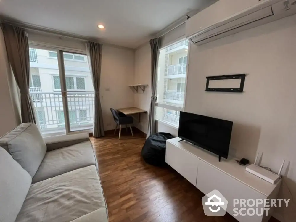 Cozy living room with polished hardwood floors, ample natural light, and a modern aesthetic, perfect for relaxation or entertaining guests.