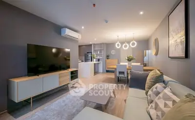 Modern living room with open kitchen, stylish furniture, and ambient lighting.