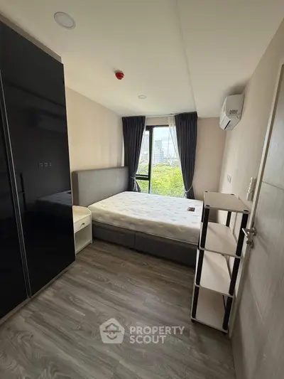 Modern bedroom with city view, sleek furniture, and ample natural light.