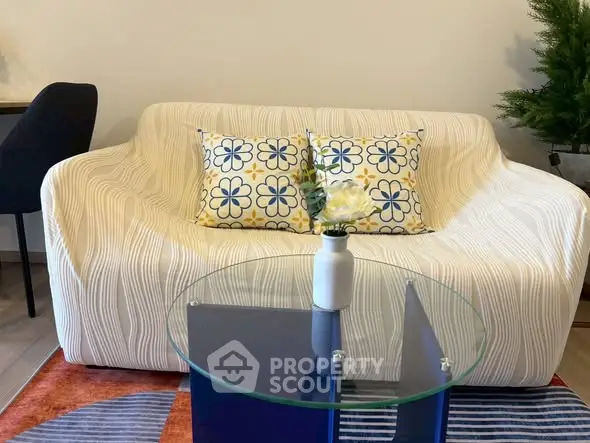 Stylish living room with modern sofa and glass coffee table, perfect for cozy gatherings.