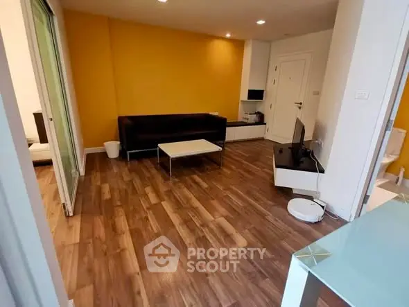 Modern living room with wooden flooring and vibrant yellow accent wall