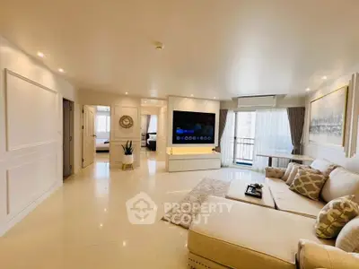 Spacious modern living room with elegant decor and large TV, featuring a cozy beige sectional sofa.