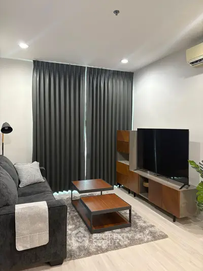 Modern living room with sleek furniture and large TV, perfect for relaxation and entertainment.