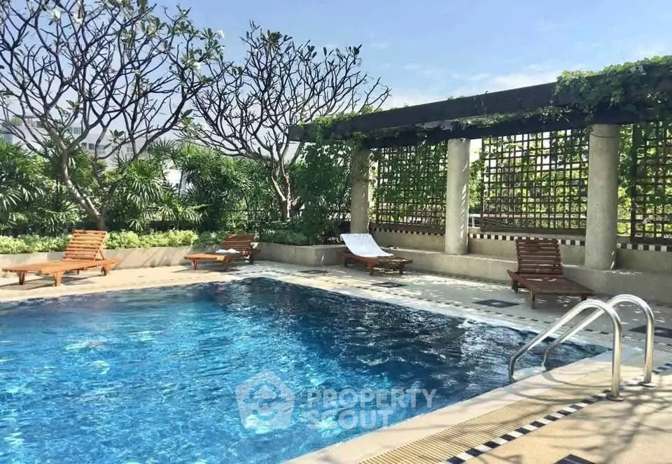 Luxurious rooftop pool with lush greenery and sun loungers, perfect for relaxation and leisure.