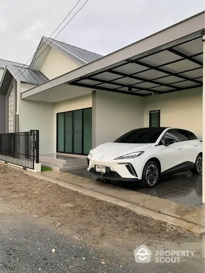 Modern house exterior with carport and sleek white SUV parked in driveway.