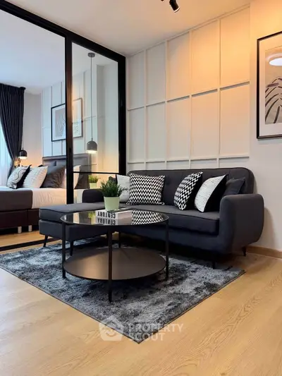 Modern living room with stylish decor and cozy seating area adjacent to bedroom.