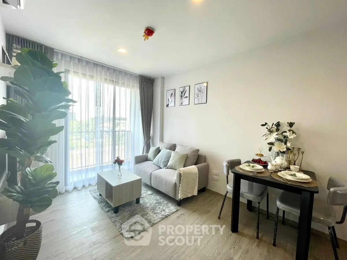 Modern living room with cozy sofa, dining area, and large window for natural light.
