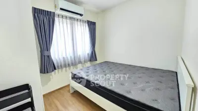 Cozy bedroom with natural light and air conditioning, perfect for restful nights.