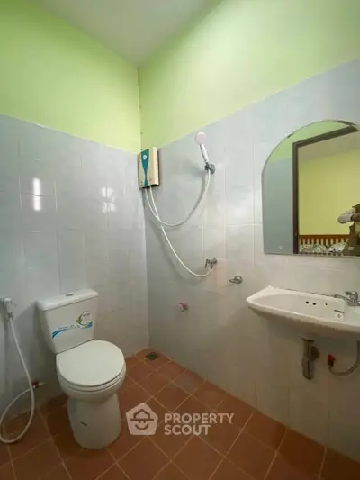 Bright bathroom with modern fixtures and tiled walls, featuring a shower and toilet.
