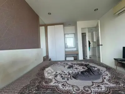 Cozy bedroom with elegant decor and ample natural light, featuring a stylish bedspread and modern furnishings.