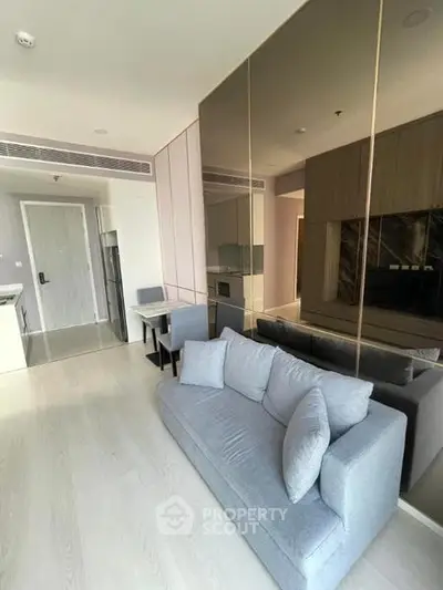 Modern living room with sleek design and open kitchen layout in a stylish apartment.