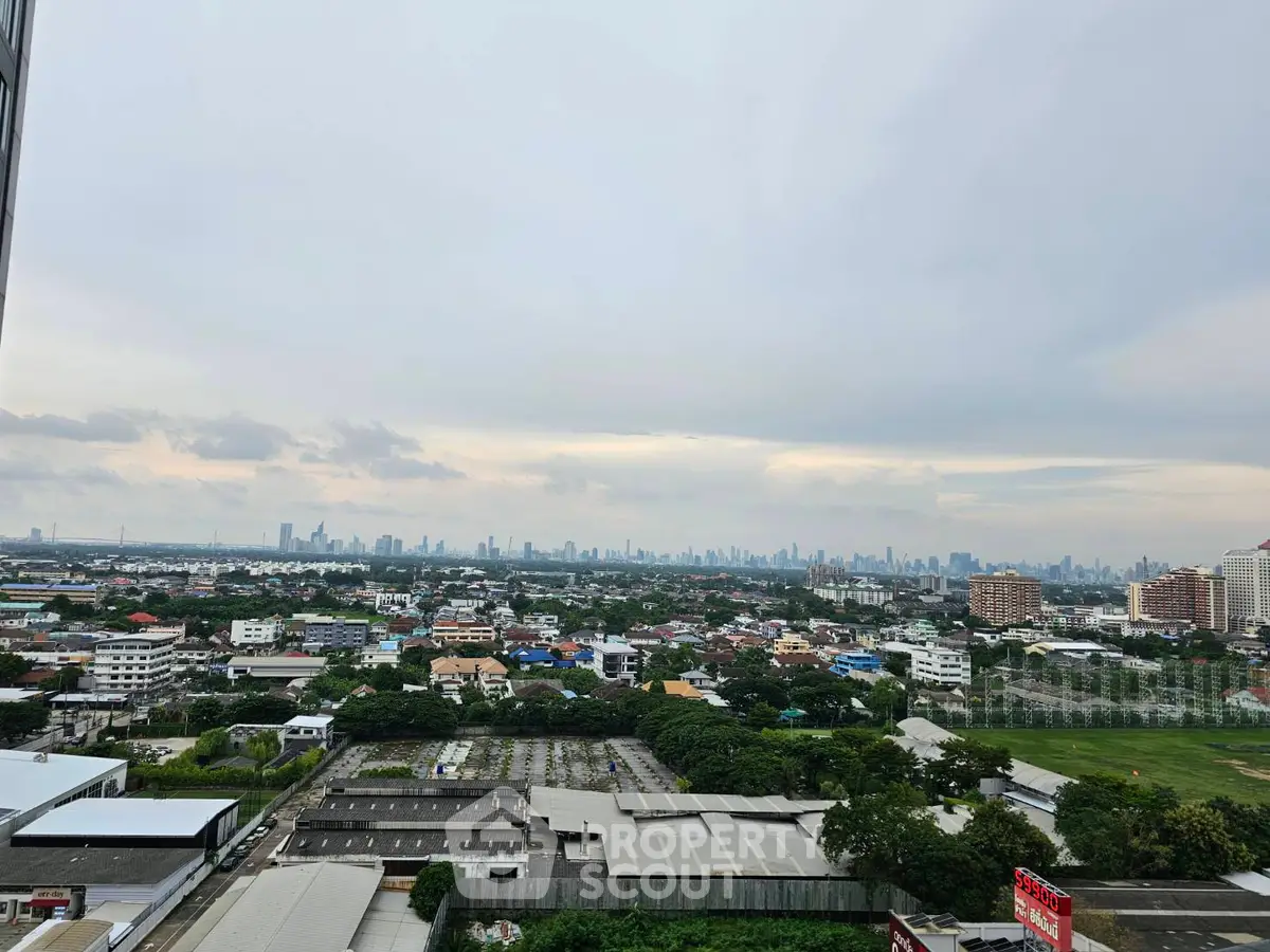 Stunning cityscape view from high-rise building showcasing urban skyline and greenery.