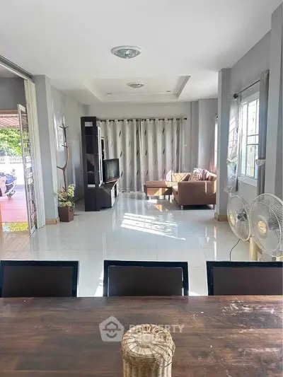 Spacious living room with modern decor and ample natural light, perfect for family gatherings.