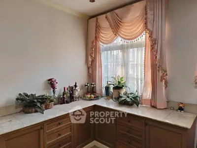 Charming kitchen corner with elegant drapes and marble countertop, perfect for cozy home decor.