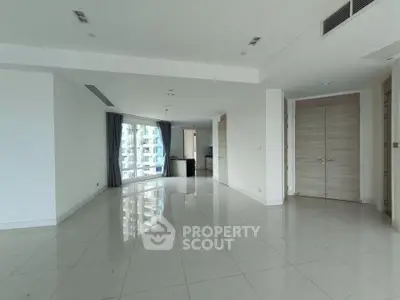 Spacious modern living room with glossy tiled floors and large windows