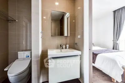 Modern bathroom with sleek design next to a cozy bedroom in a contemporary apartment.