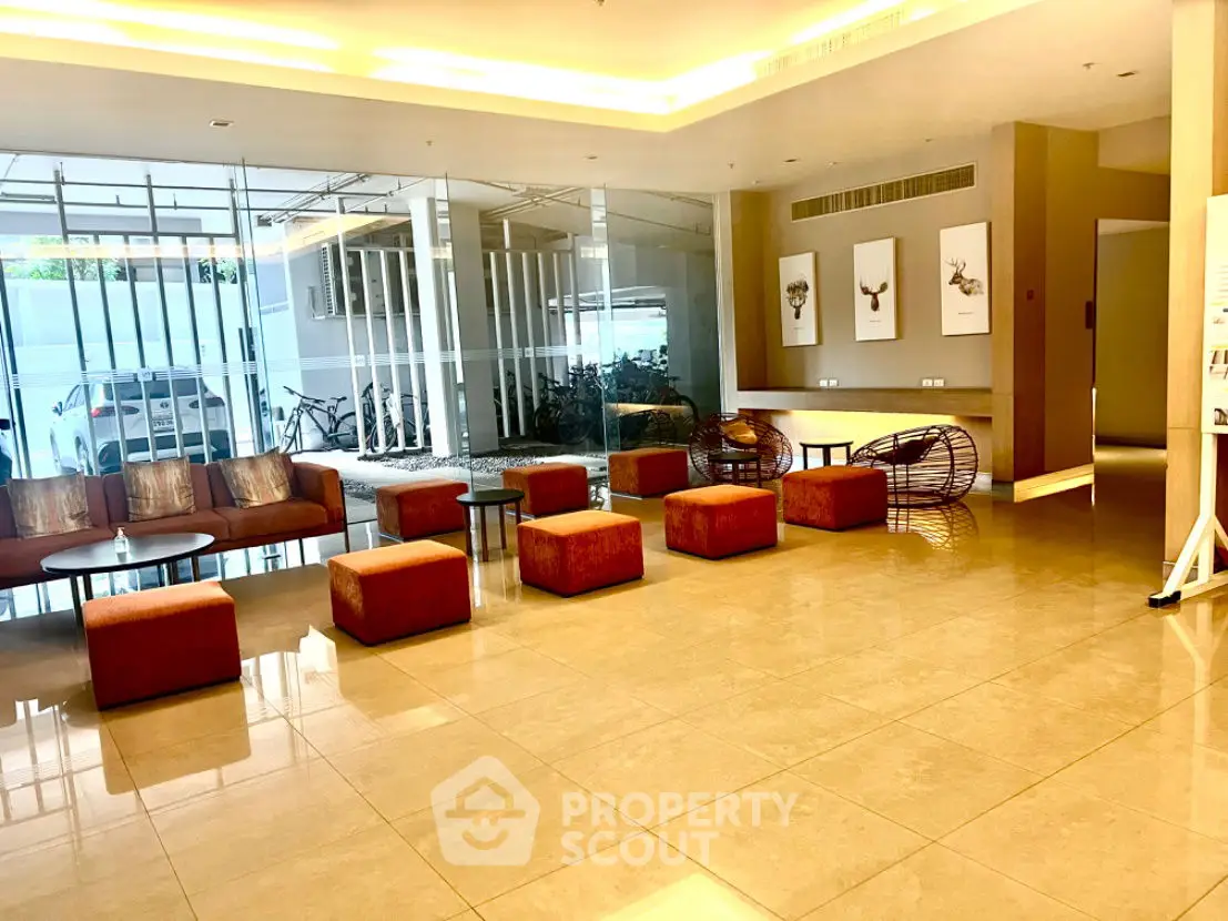 Modern lobby with stylish seating and contemporary decor in a luxurious building.