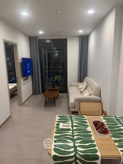 Modern living room with cozy sofa, wall-mounted TV, and stylish decor in a contemporary apartment.