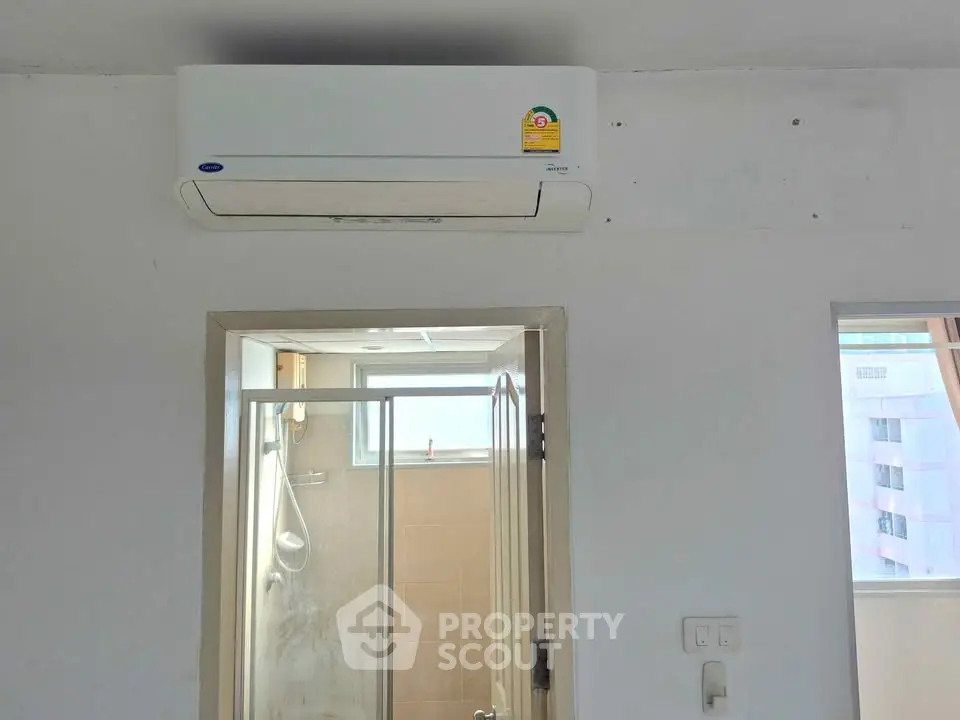 Modern interior with air conditioning and bathroom view, ideal for comfortable living.