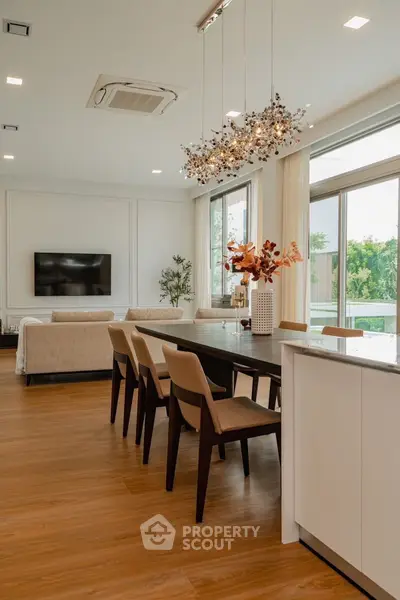 Luxurious open-plan living and dining area with elegant decor and large windows.