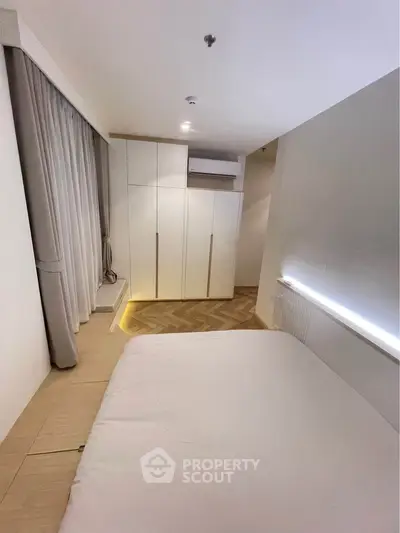 Modern bedroom with sleek design and ample storage in a contemporary apartment.