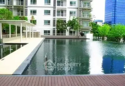 Luxurious apartment complex with serene pool and modern architecture.
