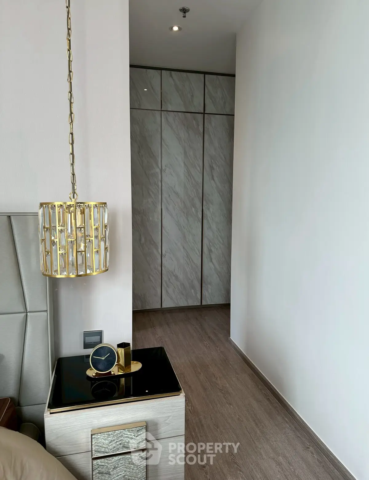 Elegant bedroom corner with modern decor and stylish lighting fixture.