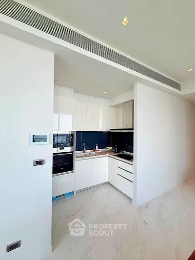 Modern kitchen with sleek white cabinetry and integrated appliances in a bright, open space.