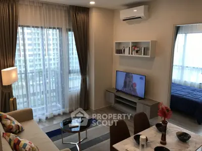Modern living room with open layout, stylish decor, and large windows offering city views.